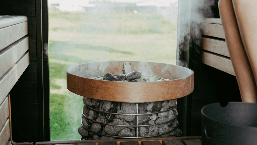 sauna heater with hot stones and steam rising inside a 4 person sauna 6kW vs8kW sauna heater