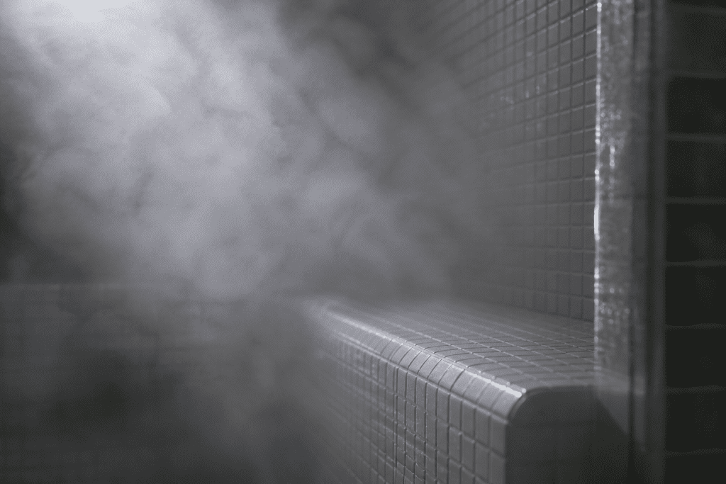 person sitting in a wooden sauna with towel and low lighting