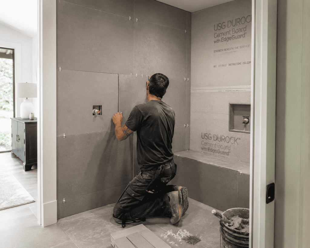 contractor installing tile in a home steam room enclosure ,steam vs sauna installation
