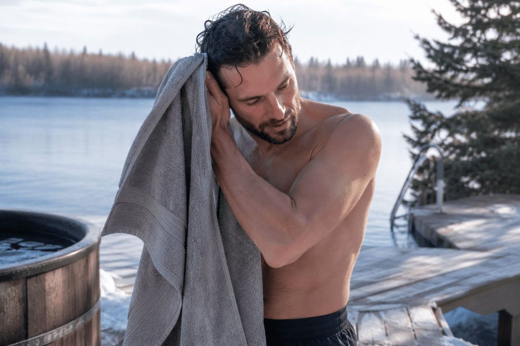 drying off with towel after cold water session outdoors warming up after ice plunge