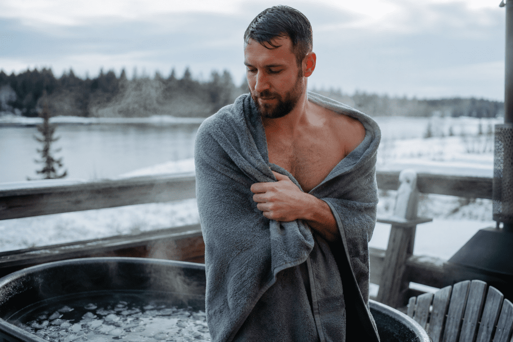 person exiting an outdoor ice bath with a towel in winter, sign Signs of Hypothermia in Ice Baths