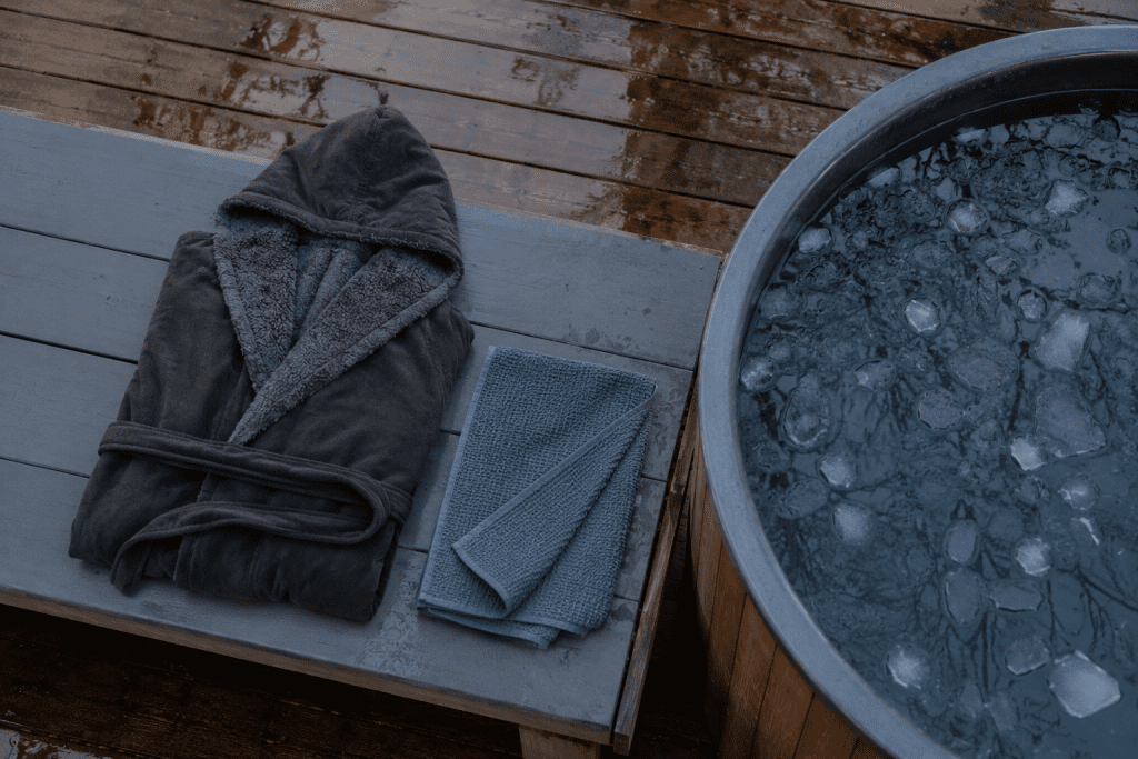 warm robe and towel laid out beside outdoor cold plunge setup